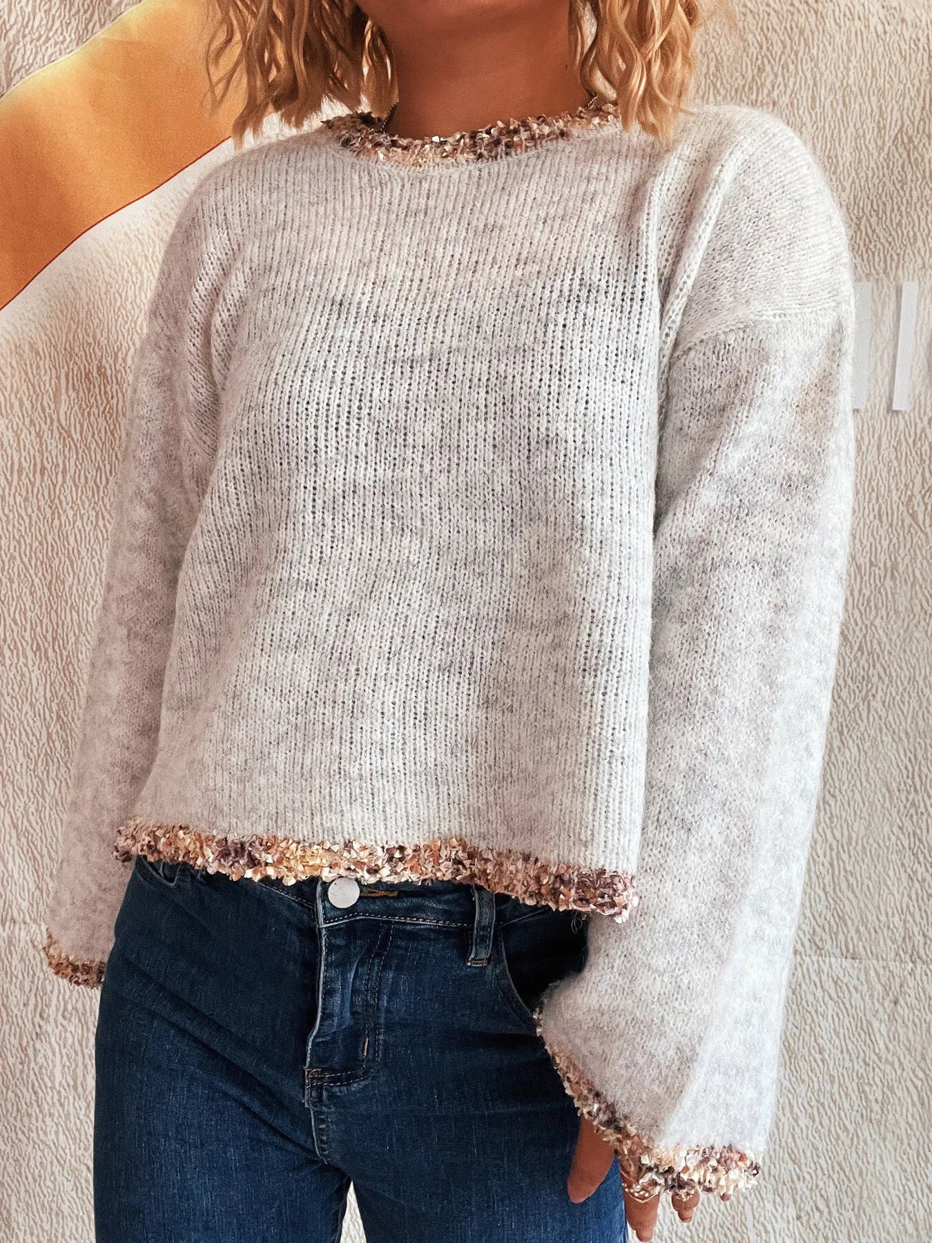 Light gray cropped round-neck knit sweater with glittery trim detail at cuffs and hem