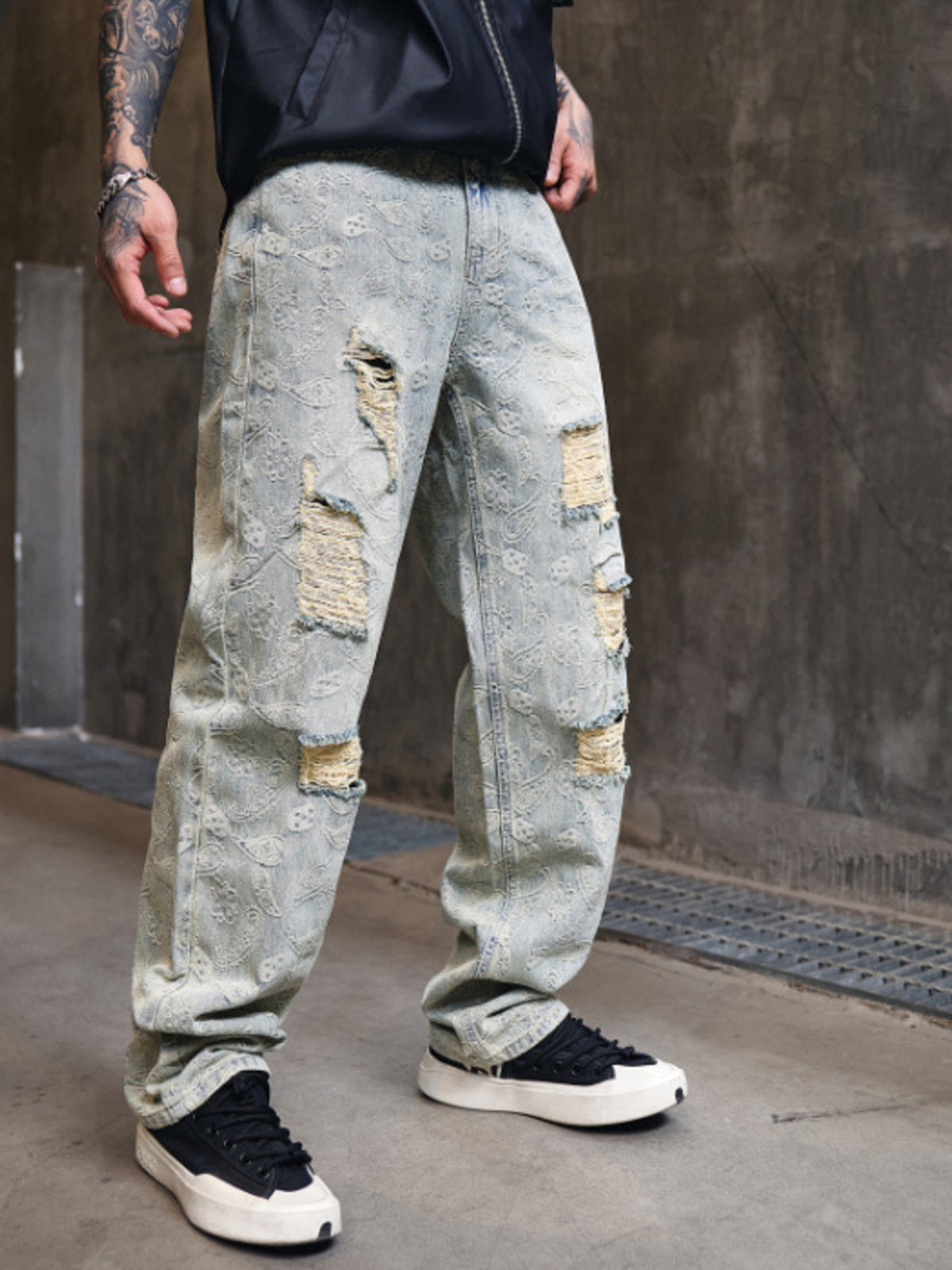 Light wash wide-leg distressed jeans, long straight legs with patched knee rips