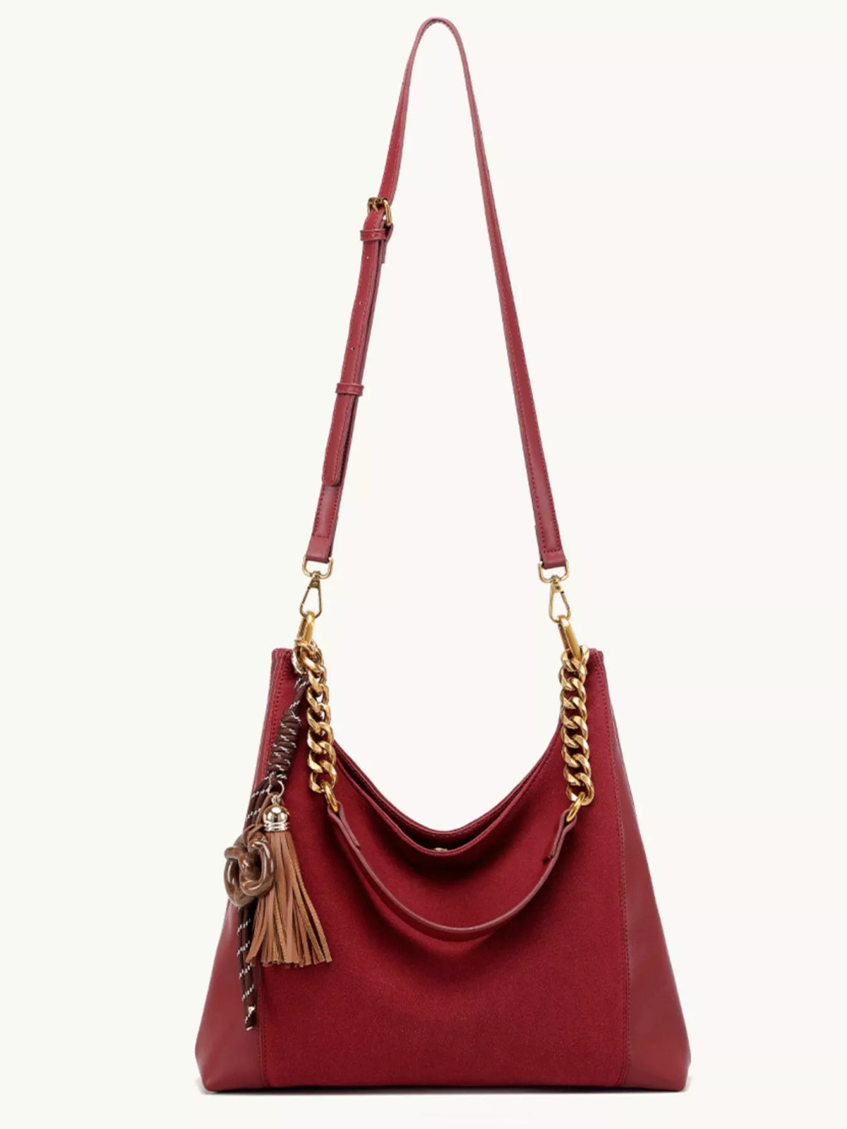 Wine red suede shoulder bag with long gold chain strap and tassel charm.