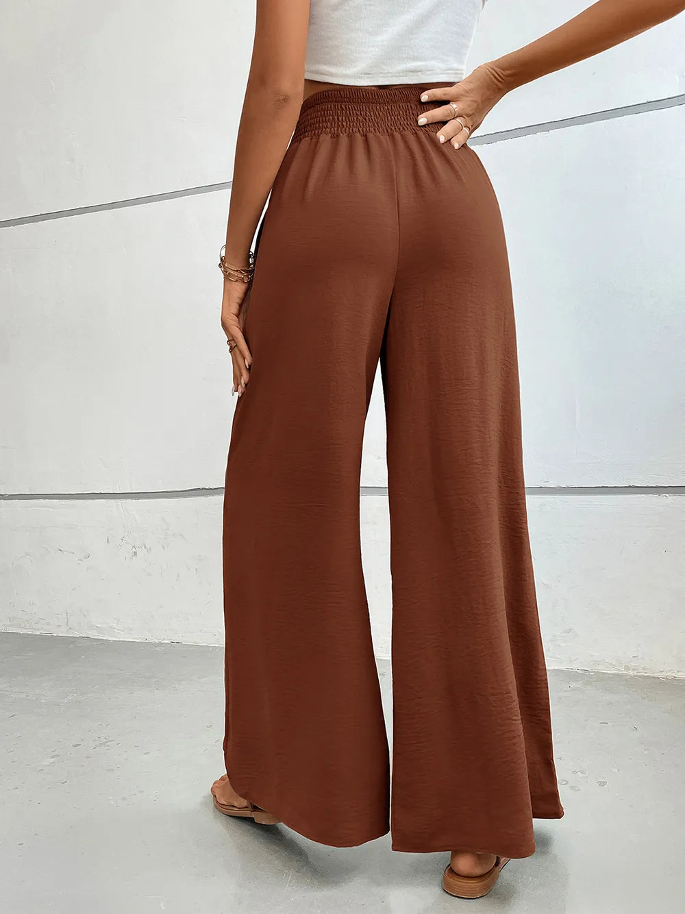 Wide-leg pants with pockets, dark brown textured fabric, full-length wide legs.