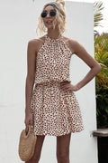 Tan printed halter mini dress with Grecian neckline and tie waist