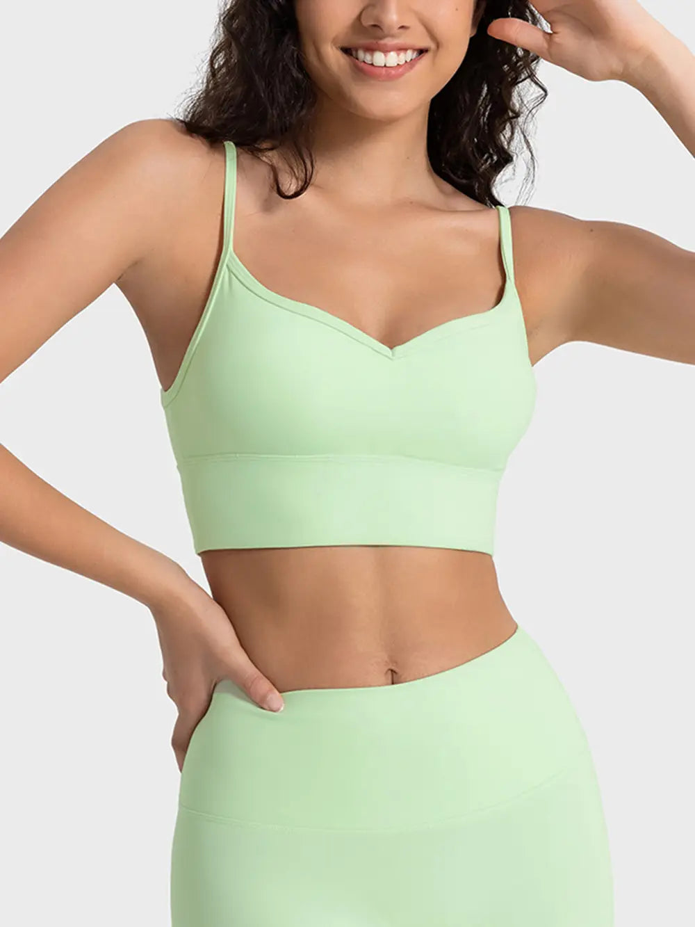 Light green spaghetti strap sport bra with V-neckline and supportive band