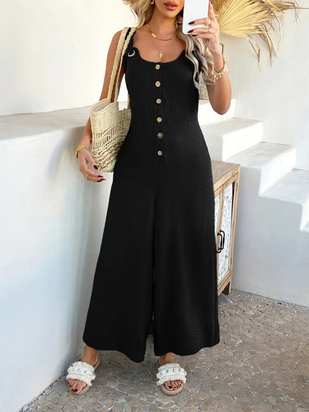 Black button-front wide-leg jumpsuit with vertical button placket and wide legs