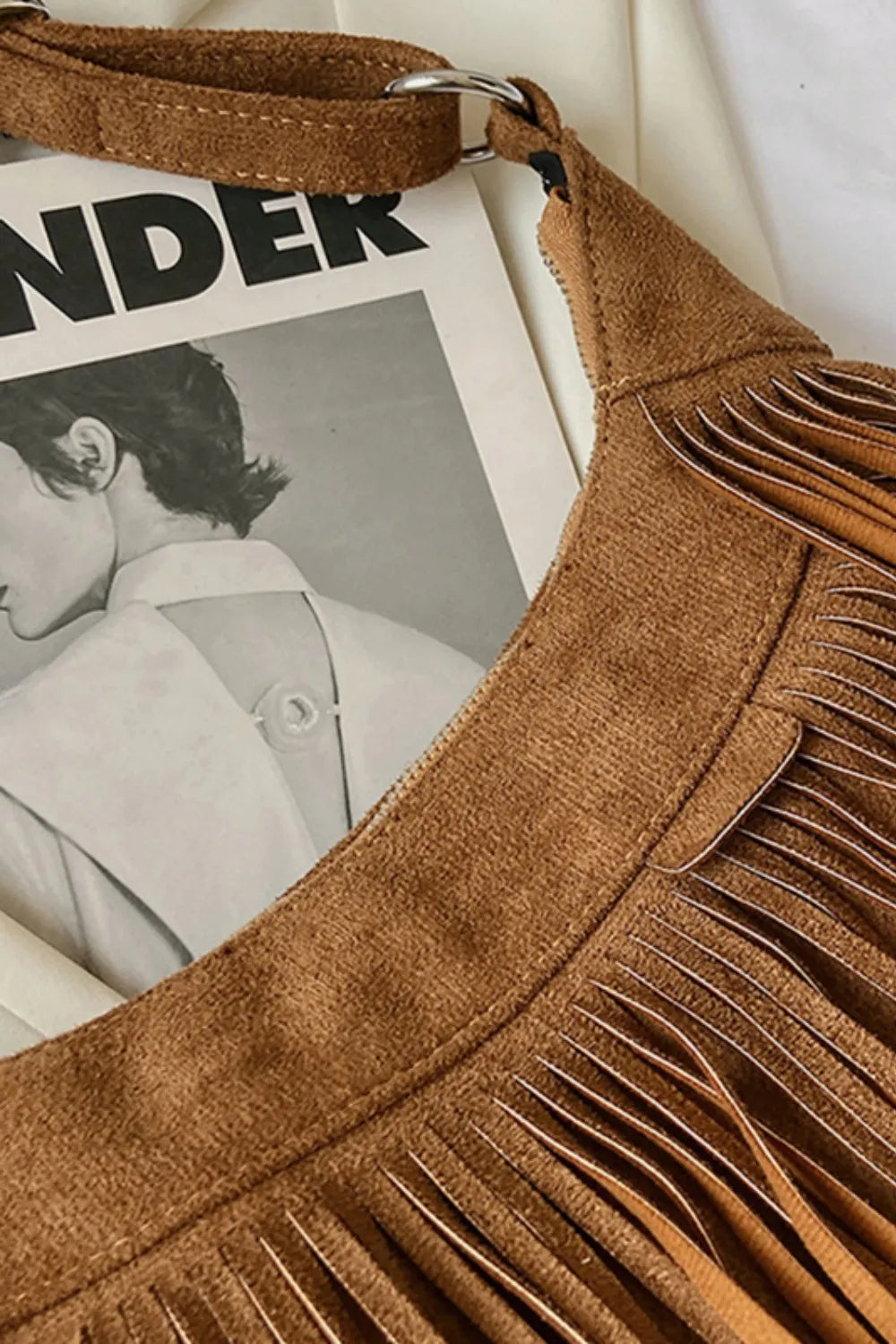 Tan suede hobo bag with fringe edging and top zip detail