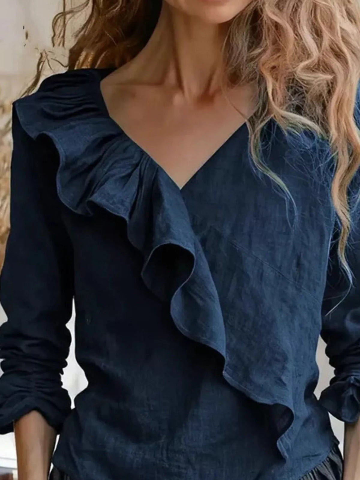 Navy ruffled V-neck blouse with layered front ruffle and long sleeves