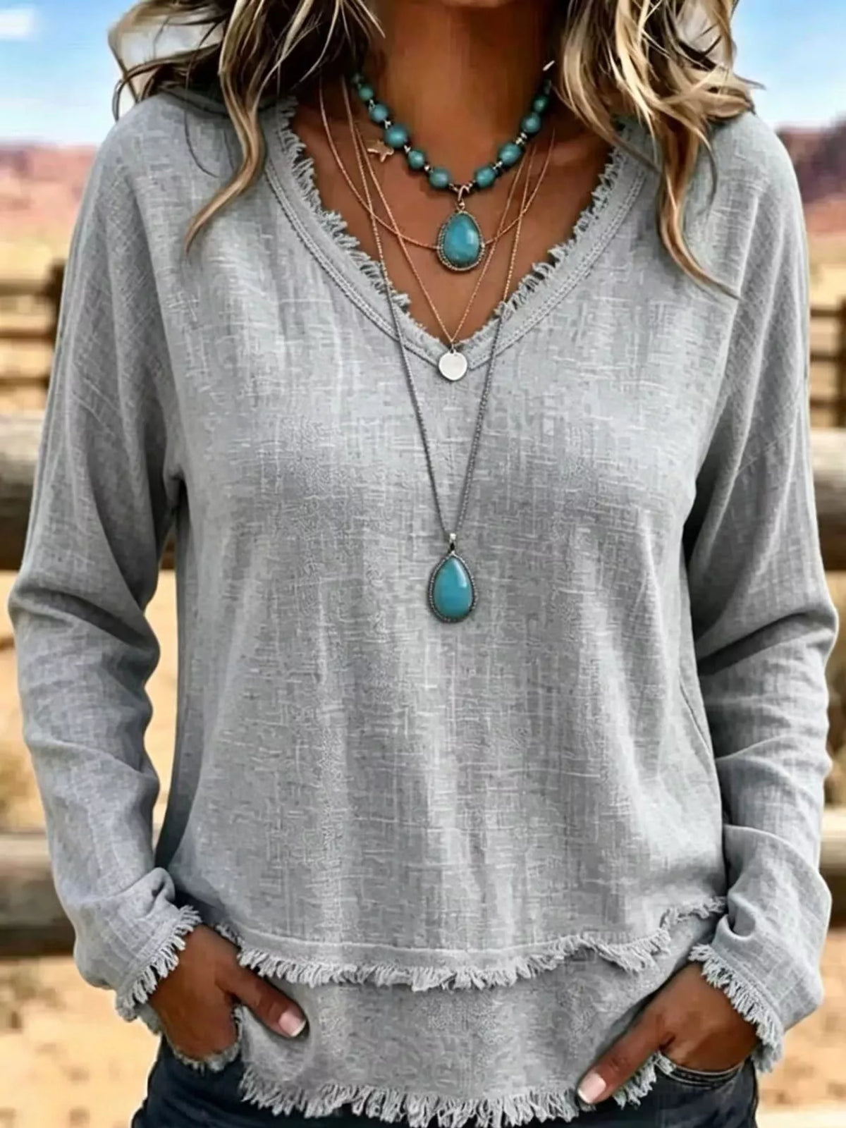 Gray V-neck relaxed blouse with frayed hem and long sleeves, loose fit
