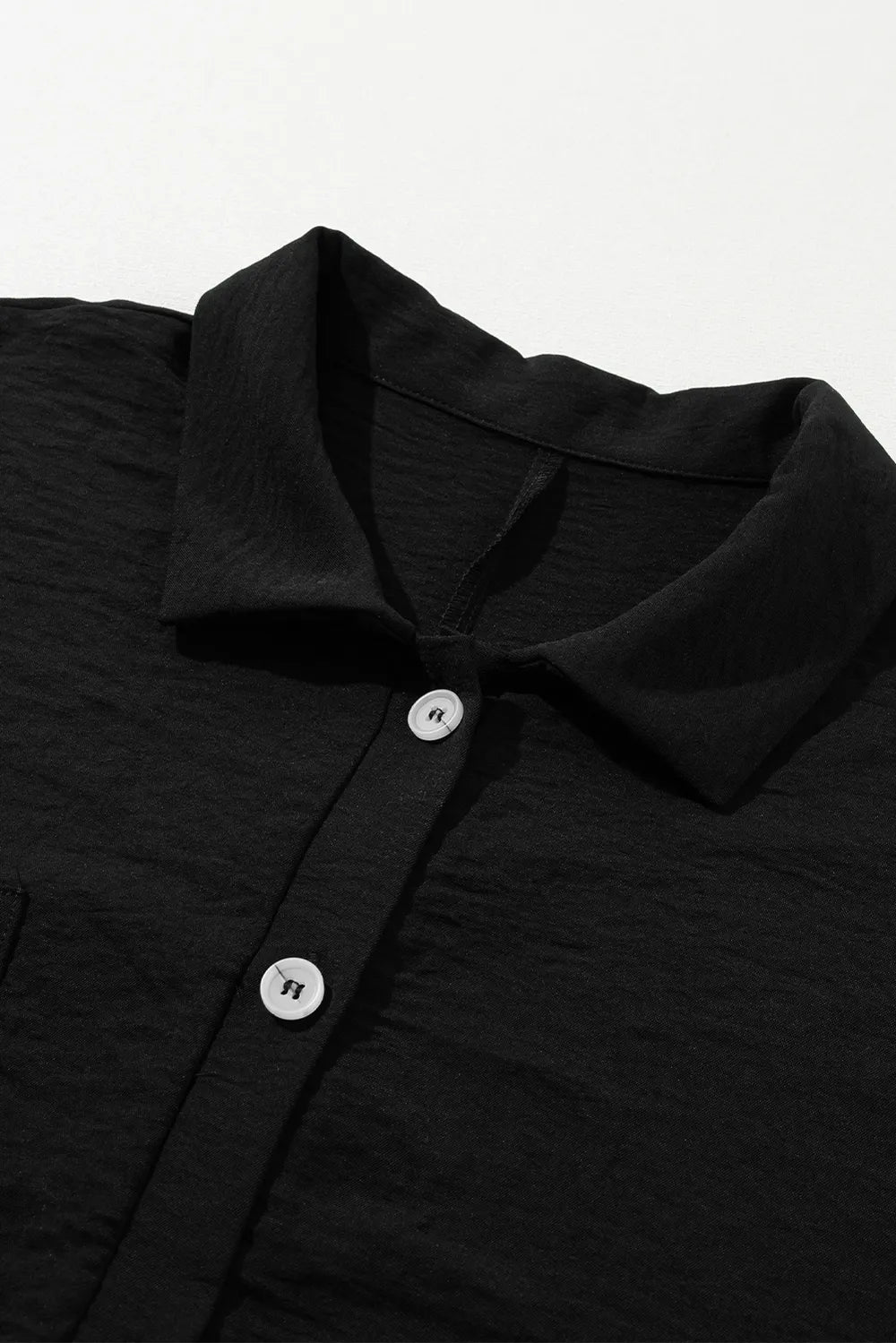 Black half-button collared romper neckline with button placket detail