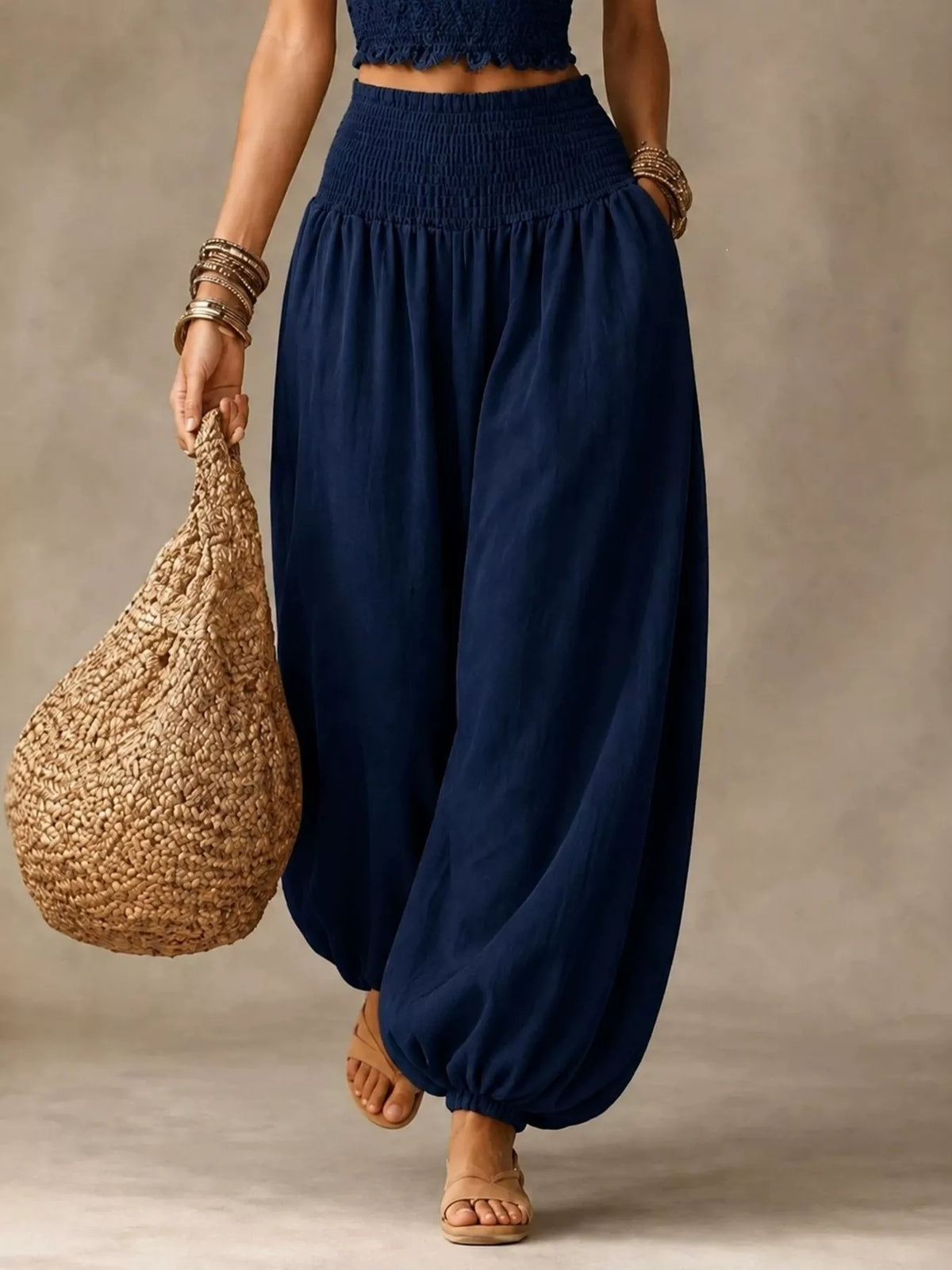 Navy blue elastic-waist smocked harem pants with wide legs and gathered cuffs