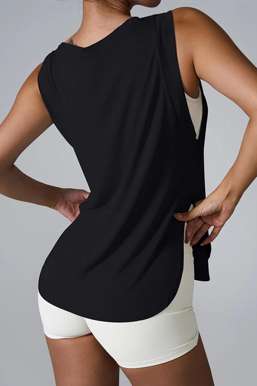 Black sleeveless active tank top with round neck and side slit hem opening