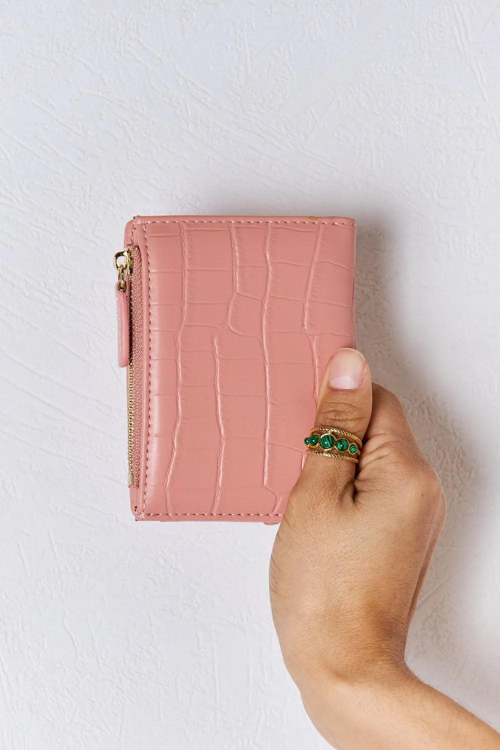 Pink textured vegan leather mini wallet, front view with gold zipper and snap button.