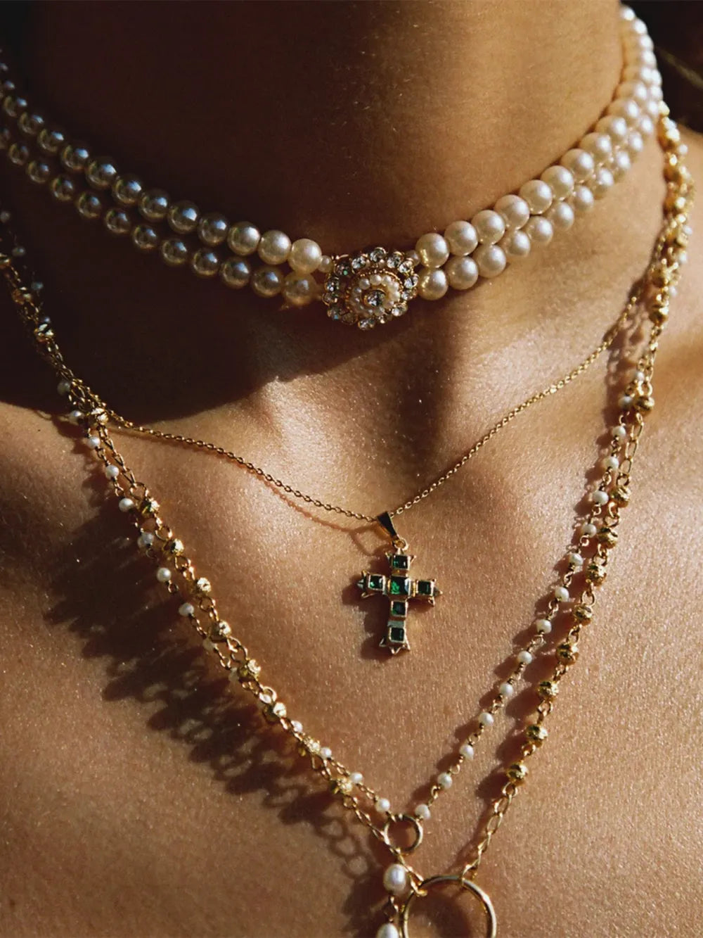 Gold-tone cross pendant necklace with green square stones and a fine chain