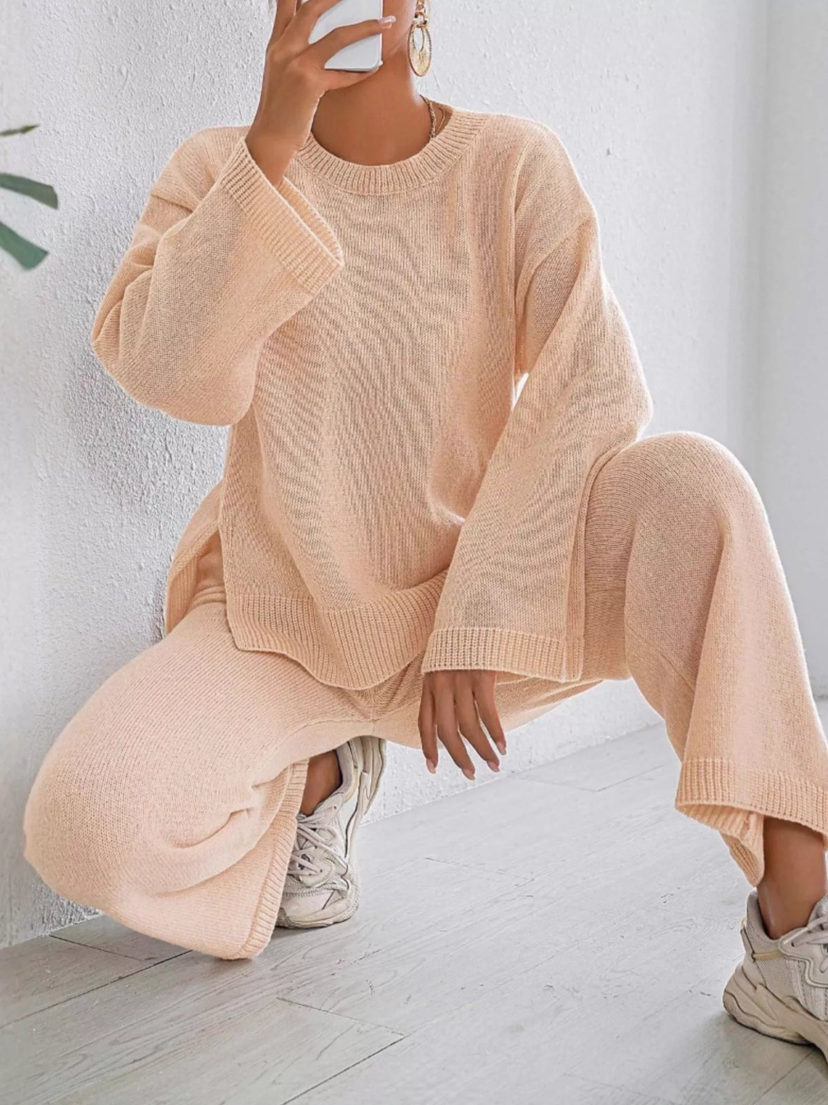 Apricot knit sweater and pants set with dropped shoulders, crew neck, and ribbed hem detail.