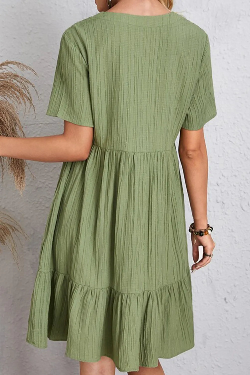 Back view green ruched V-neck short-sleeve tiered dress with gathered waist