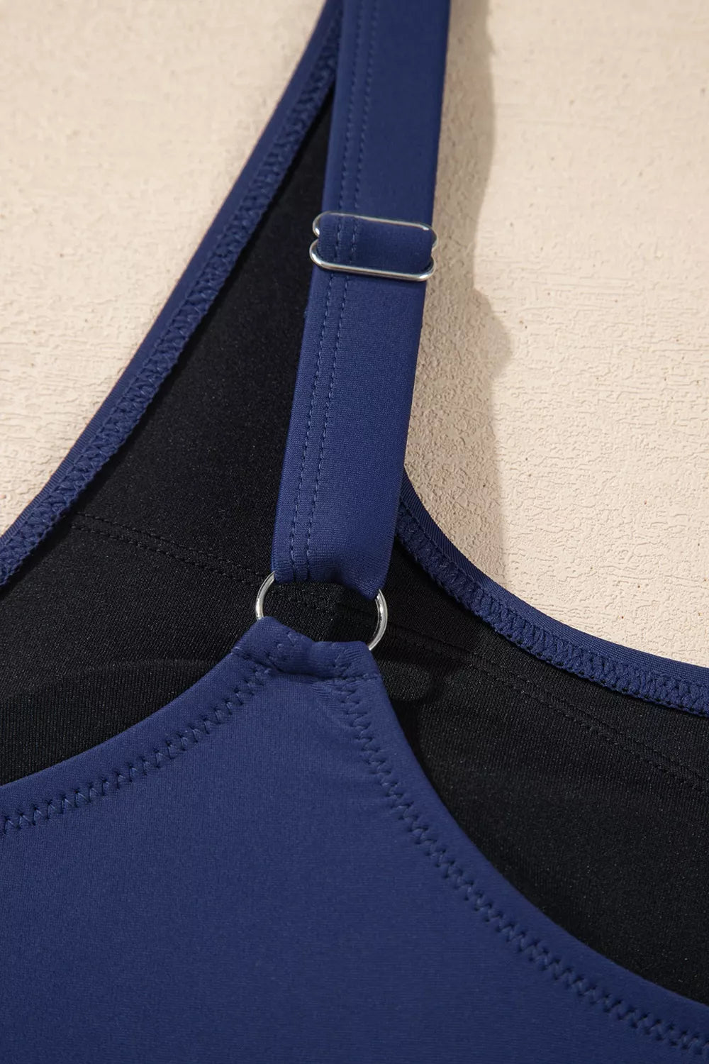 Navy swimsuit with adjustable shoulder strap and black inner support trim