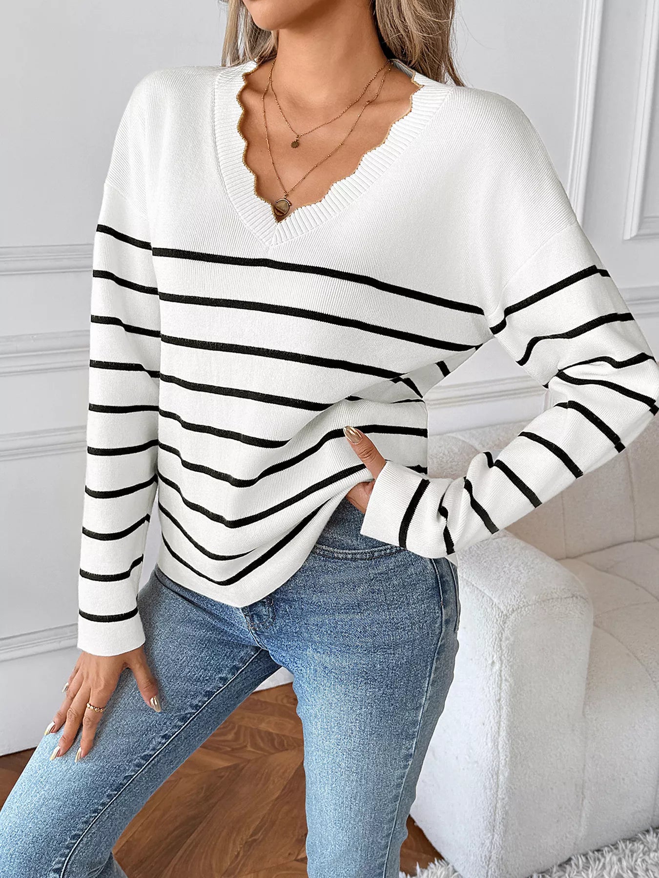White V-neck long sleeve sweater with black stripe bands, relaxed fit and ribbed neckline