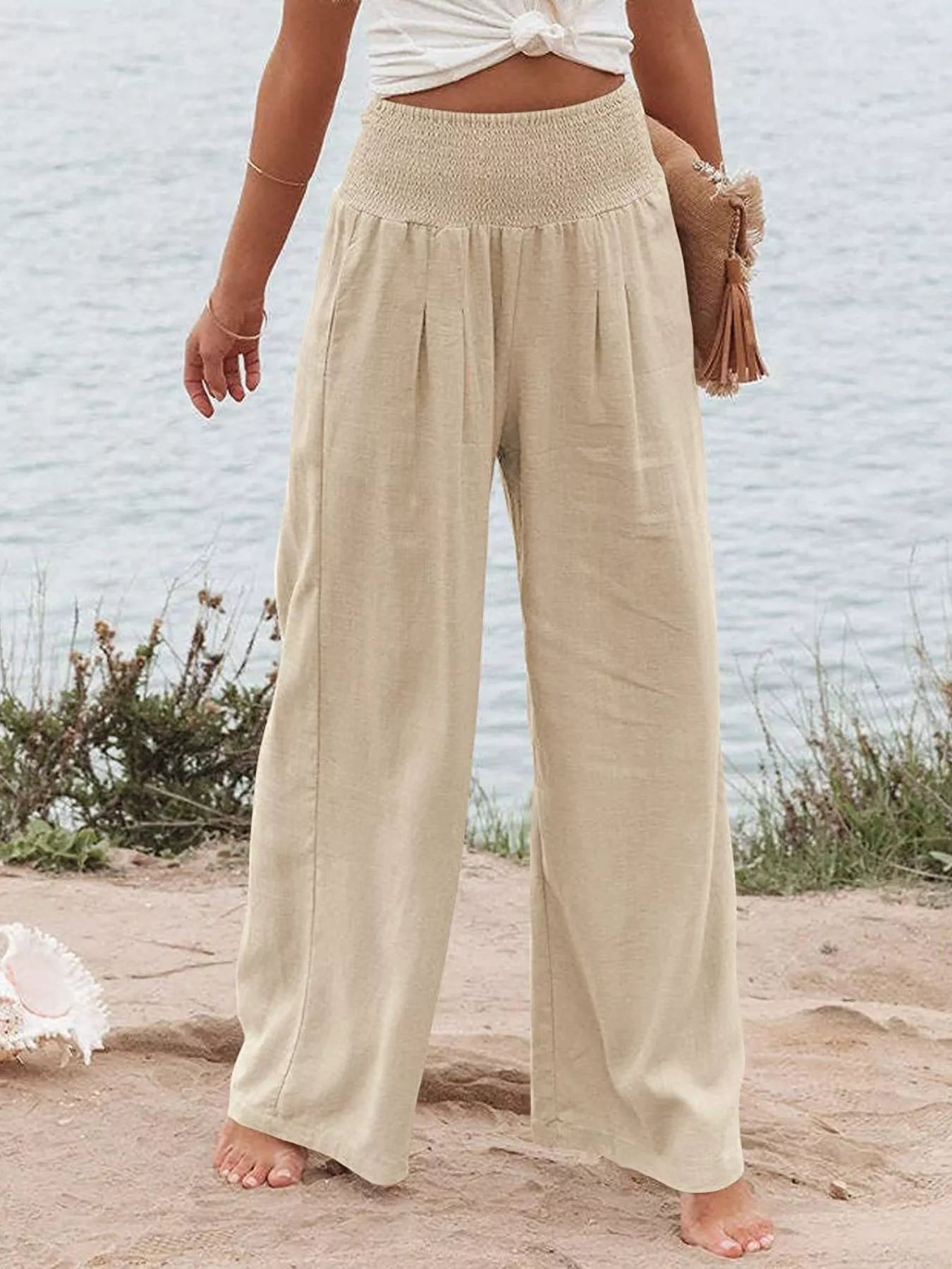 Light beige smocked high-waist wide-leg pants with gathered waist and flowy fit