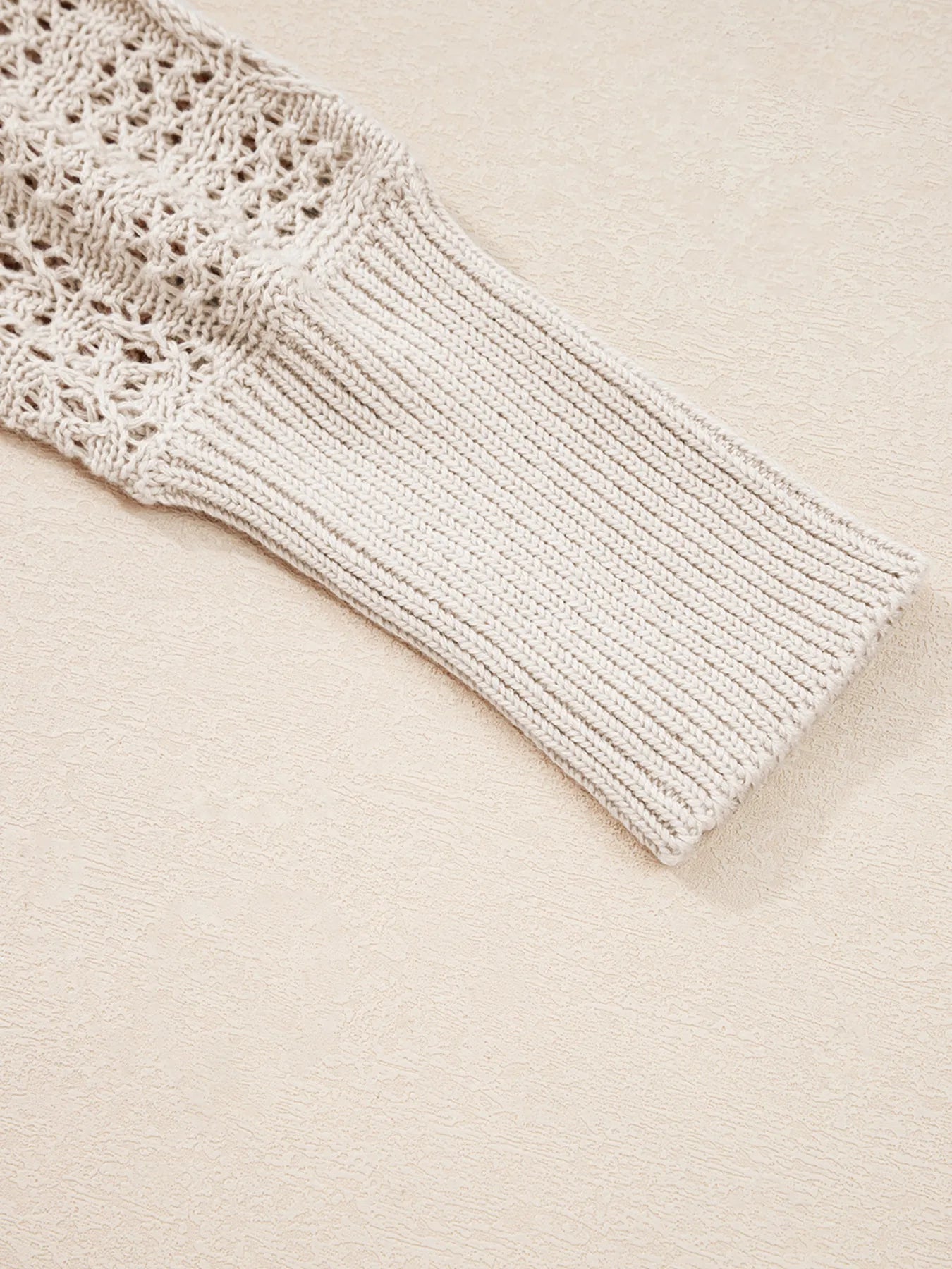 Beige knit cardigan sleeve cuff with ribbed trim and textured hollow stitches