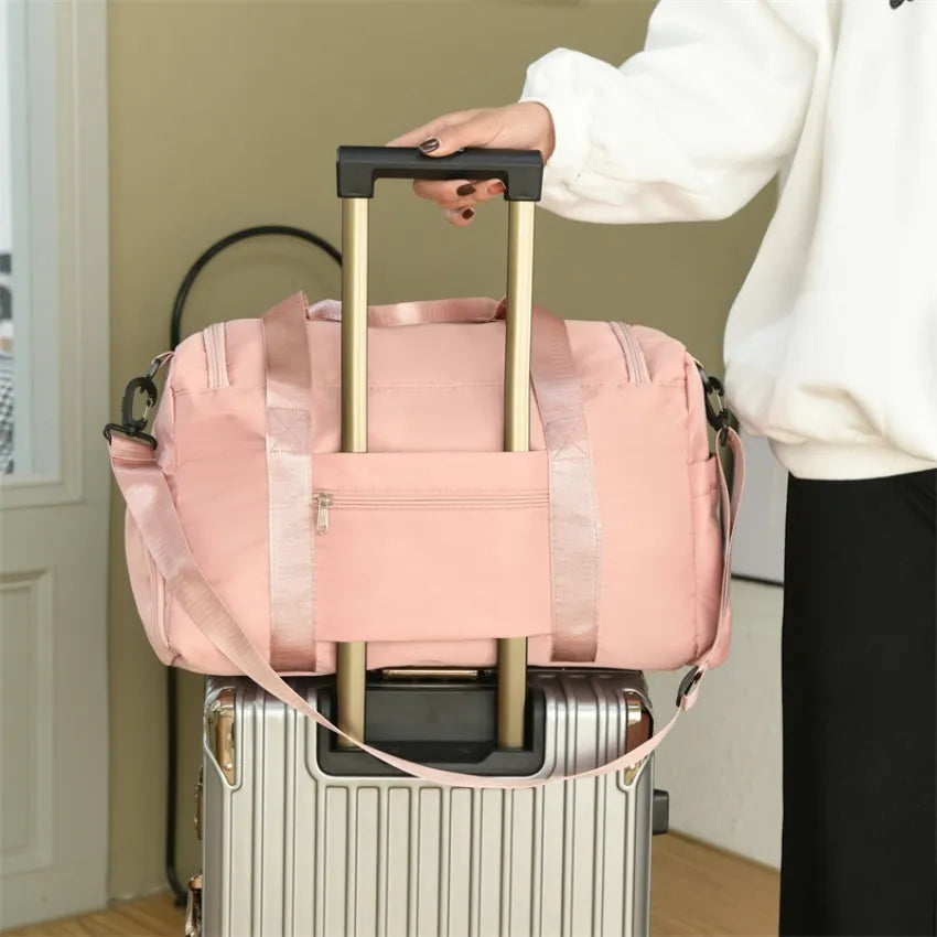 Large pink duffle travel bag with front pocket, side handles, and top carry strap