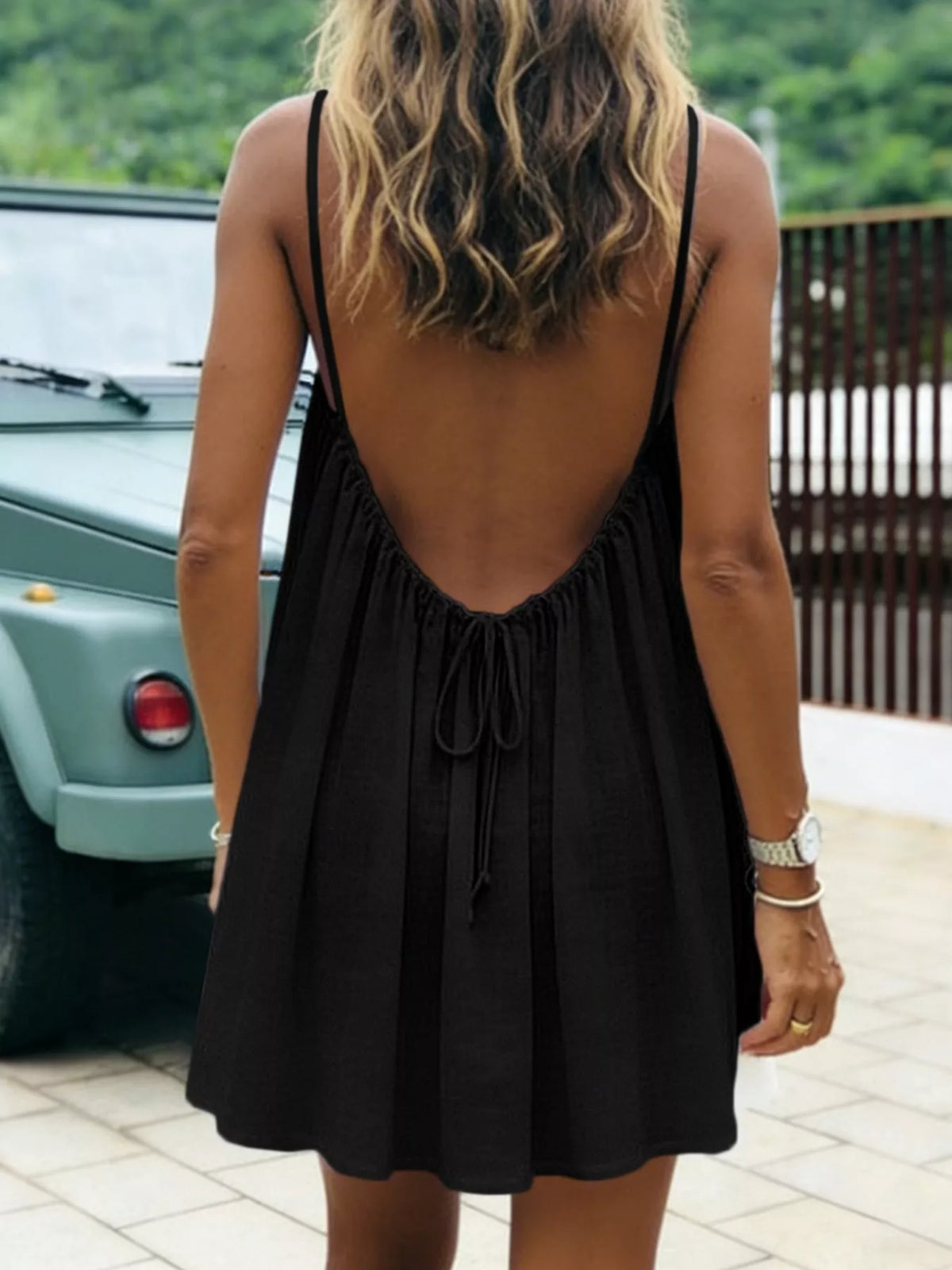 Black backless mini dress with open scoop back and tie detail at center