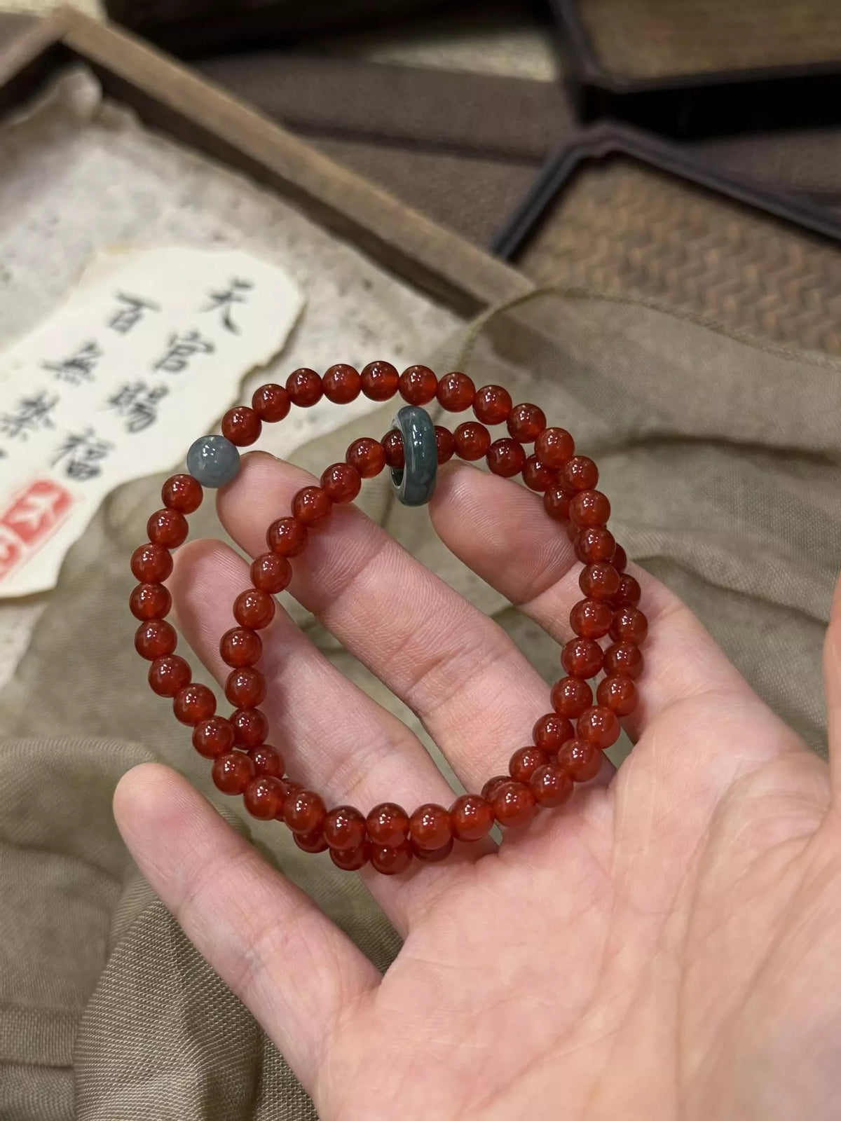 Double-layer burgundy agate bead bracelet with two round bead loops and teal accents