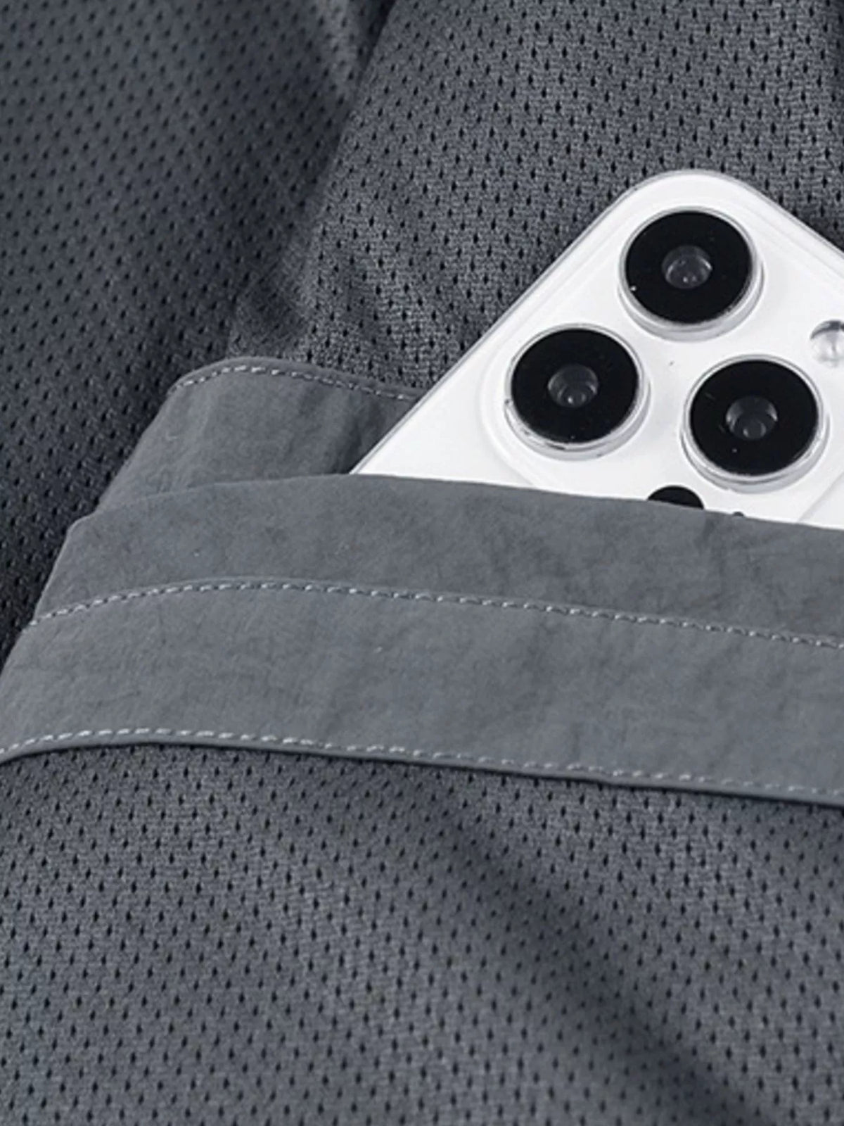 Gray jacket fabric close-up with textured panel and visible stitching