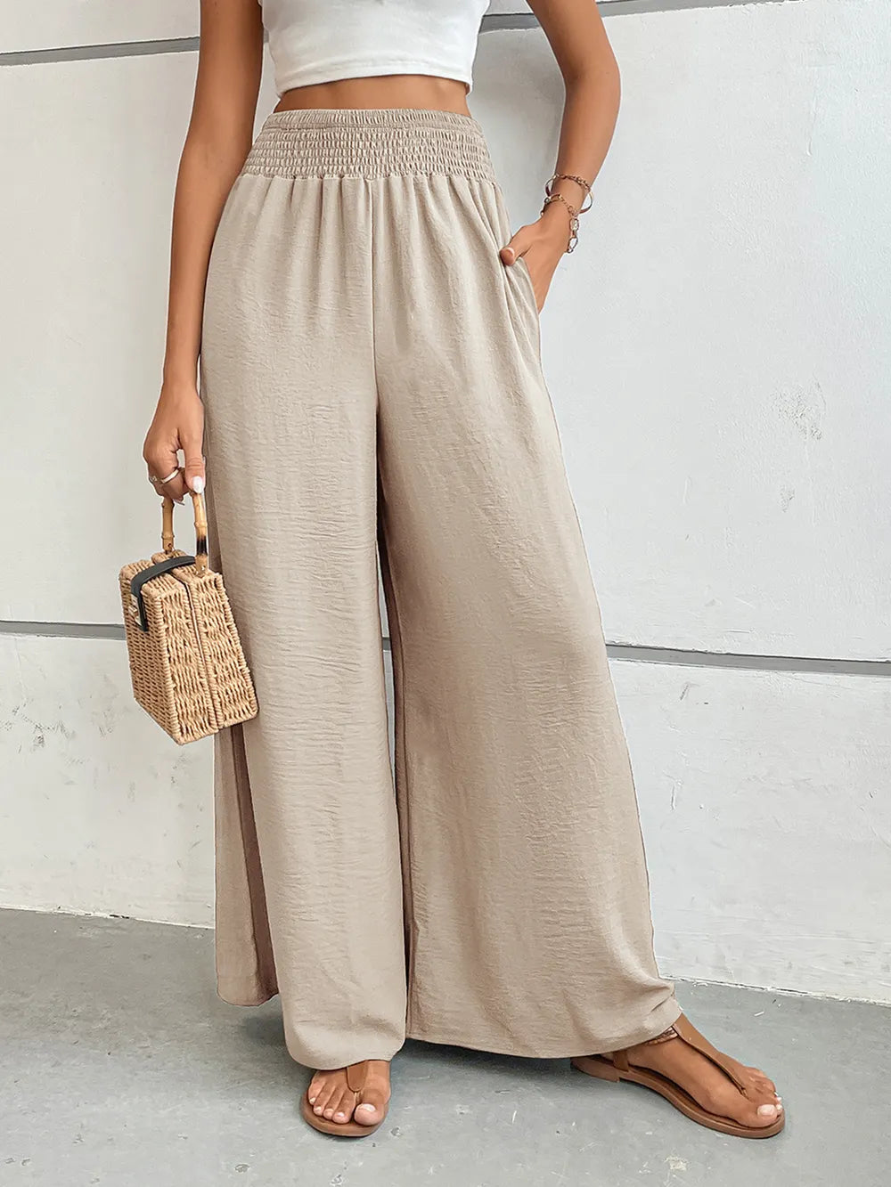 Wide-leg pants with pockets, light beige textured fabric, draped wide legs.