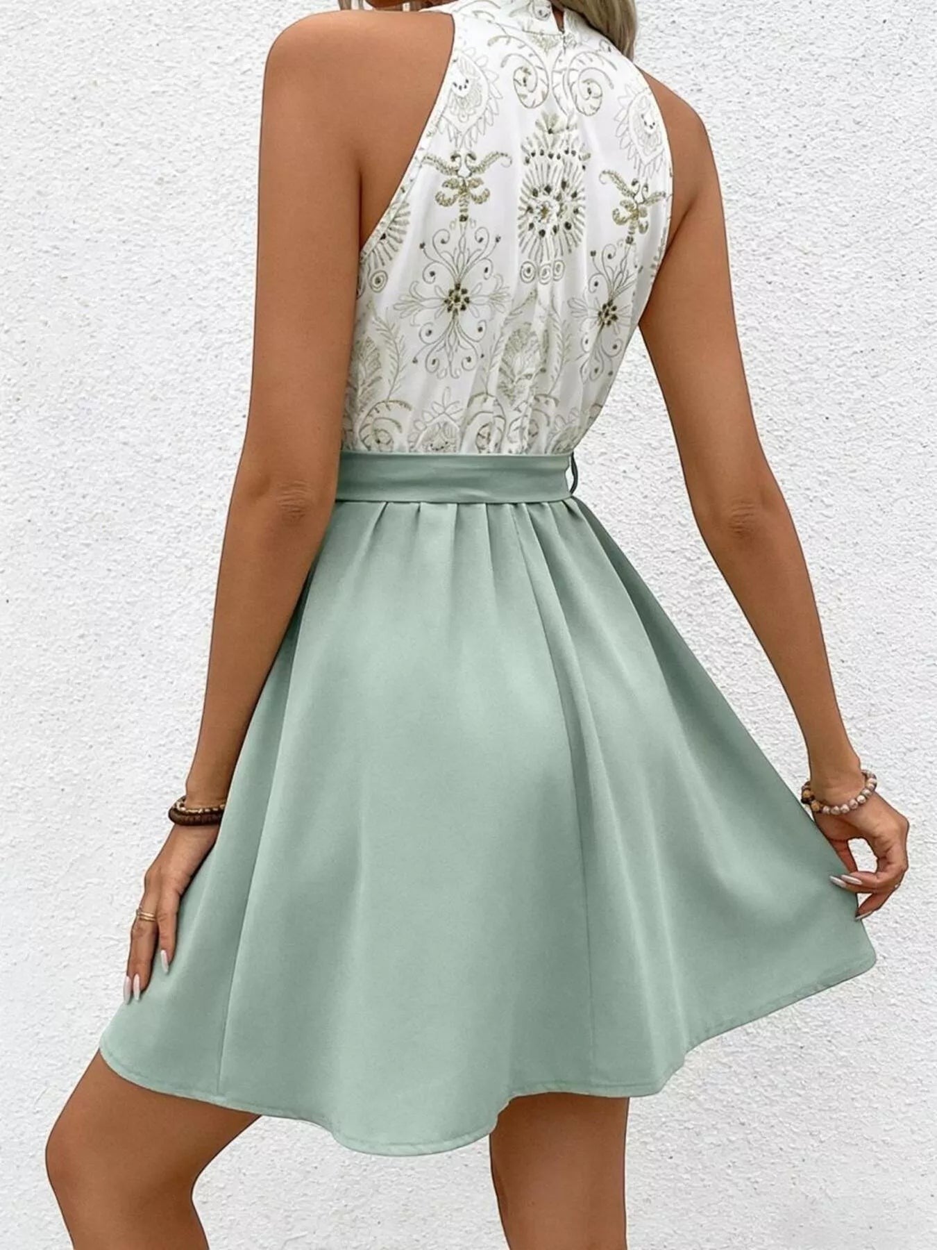 Cedar & Moore sleeveless A-line dress in sage green with a white bodice featuring gold embroidered details and a tie waist.