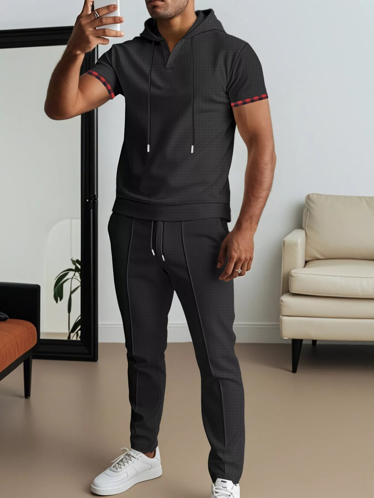 Black short-sleeve hoodie set with front pocket, drawstring hood, and joggers