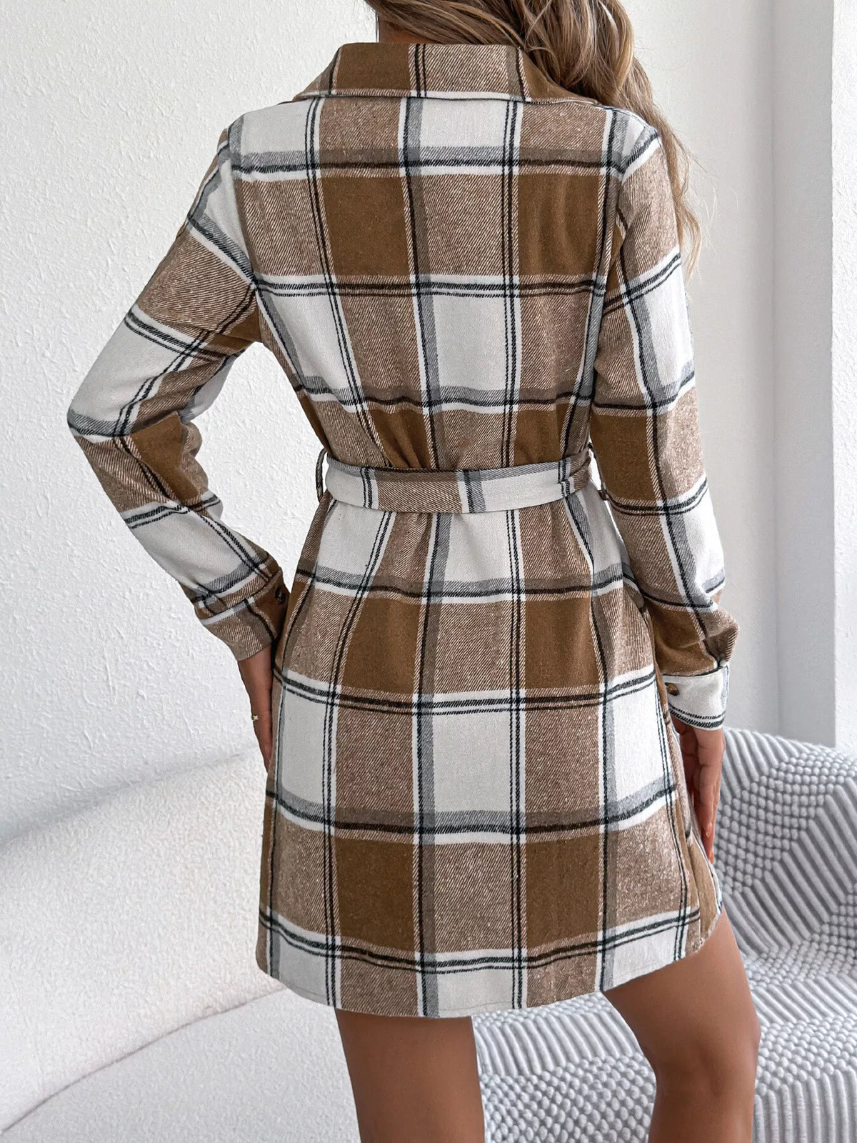 Back view of brown plaid belted button shirt dress with collar and long sleeves.