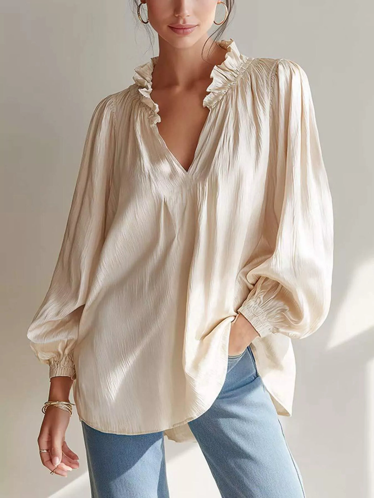 Beige long-sleeve blouse with ruffle-trim V-neck and gathered sleeve cuffs