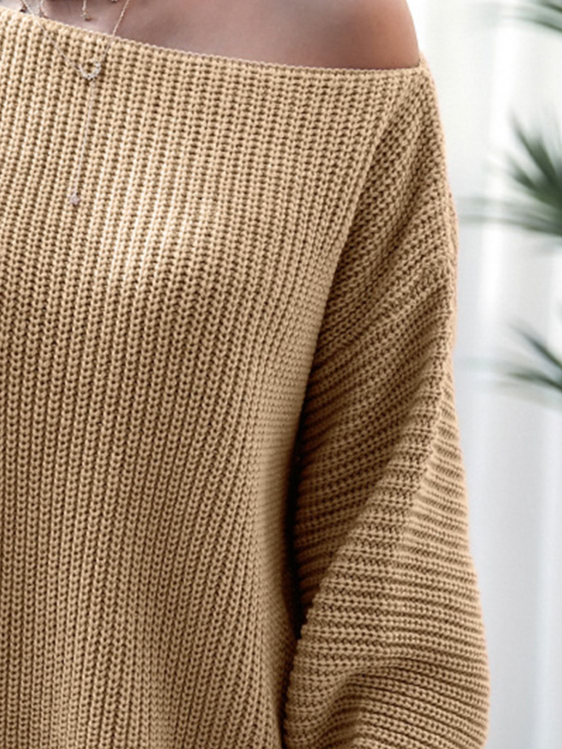 Close-up of rib-knit mini sweater dress fabric in light khaki, long sleeve cuff.