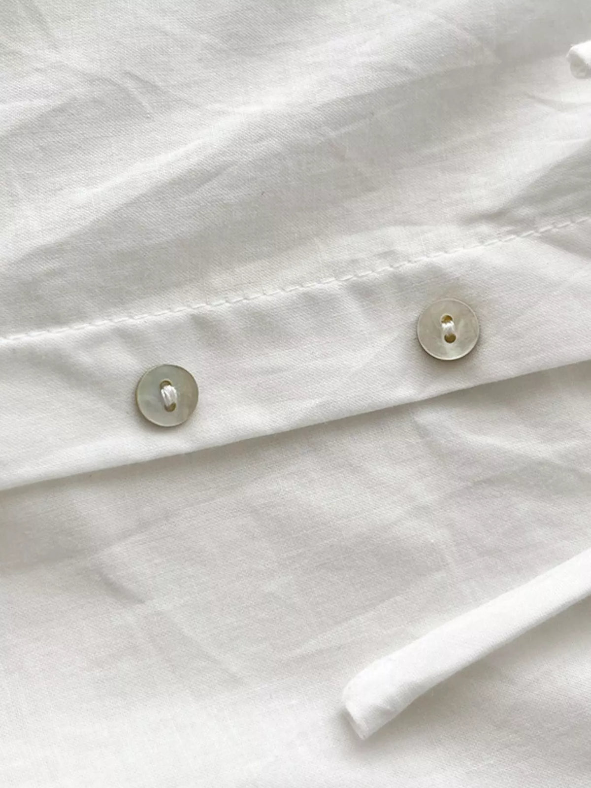 White cotton maxi dress front with round buttons and softly gathered fabric
