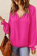 Hot pink lantern sleeve blouse with notched V-neck and gathered cuff details