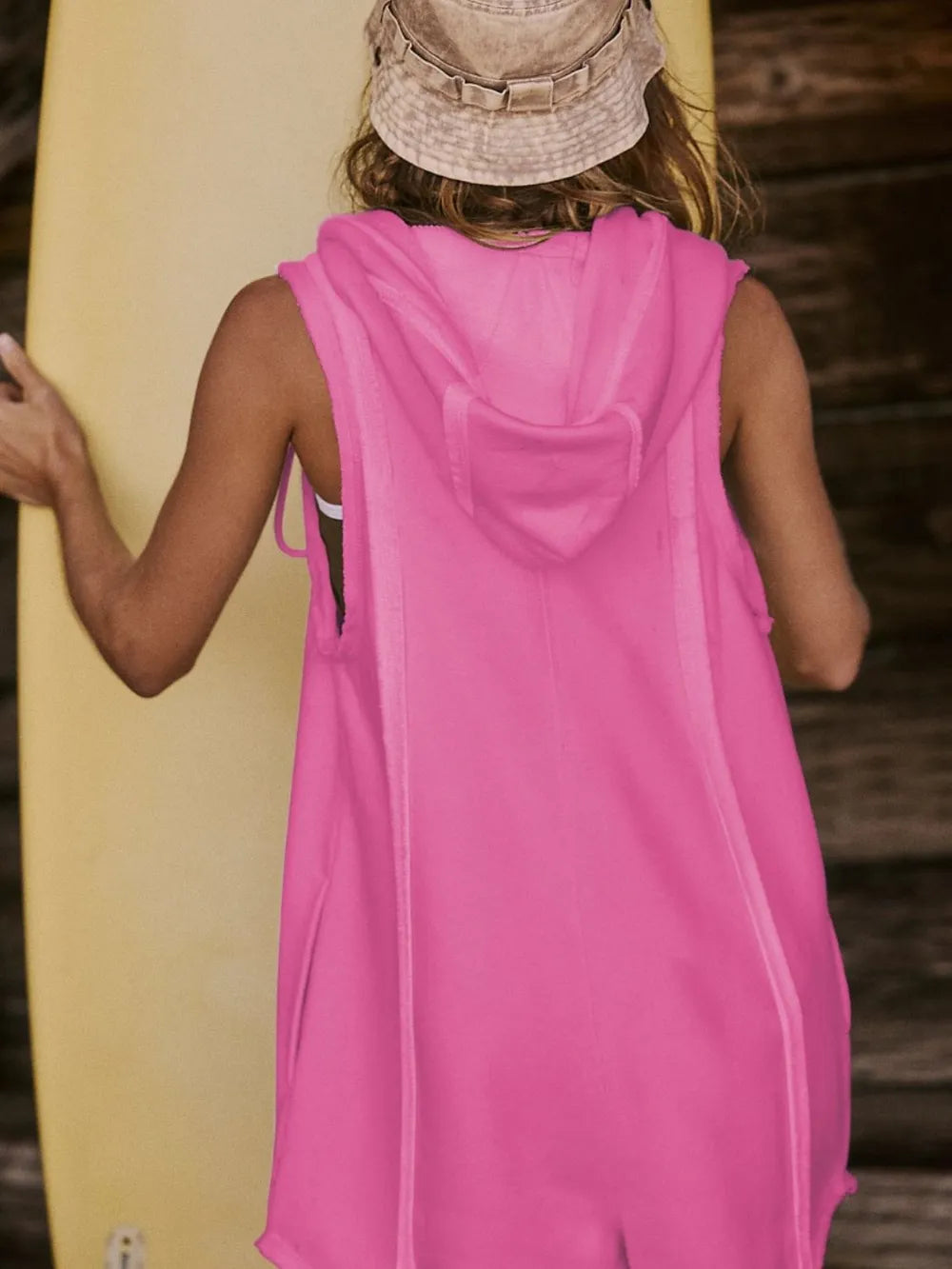 Hot pink hooded sleeveless romper, back view with hood and drawcord ties