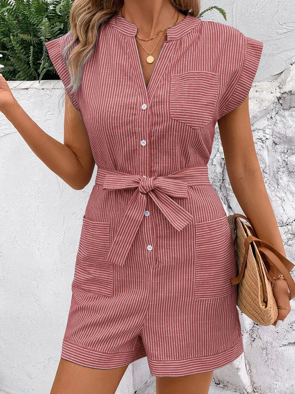 Striped notched tie-waist romper in dusty pink, front view with button placket and bow