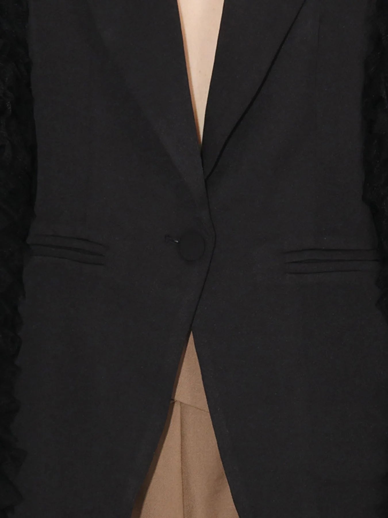 Black blazer front close-up showing one-button closure and notch lapel