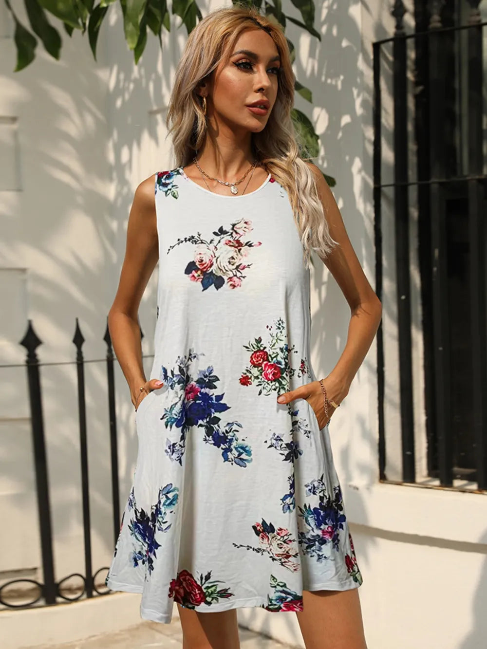 Sleeveless round-neck dress with white base and blue and red floral print