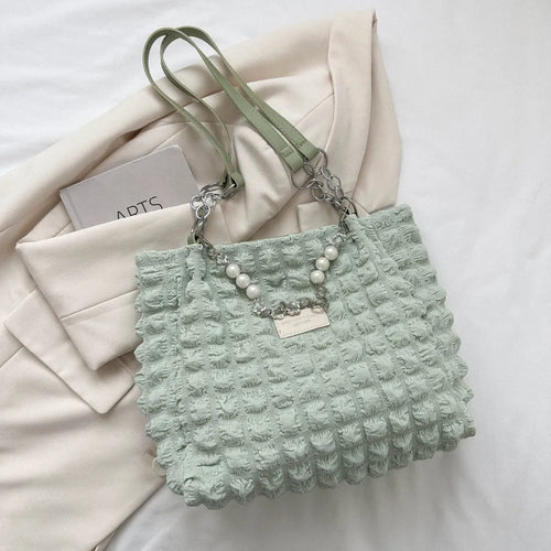Light green bubble-textured tote bag with top handle, chain strap, and pearl charm