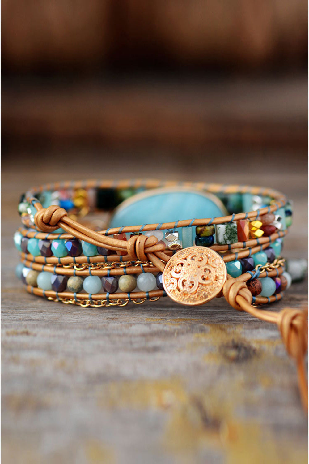 Triple-layer beaded bracelet with aqua oval stone, braided cords, and round gold charm