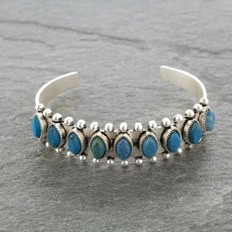 Open alloy bracelet with oval teal-blue stones and silver bead ball accents
