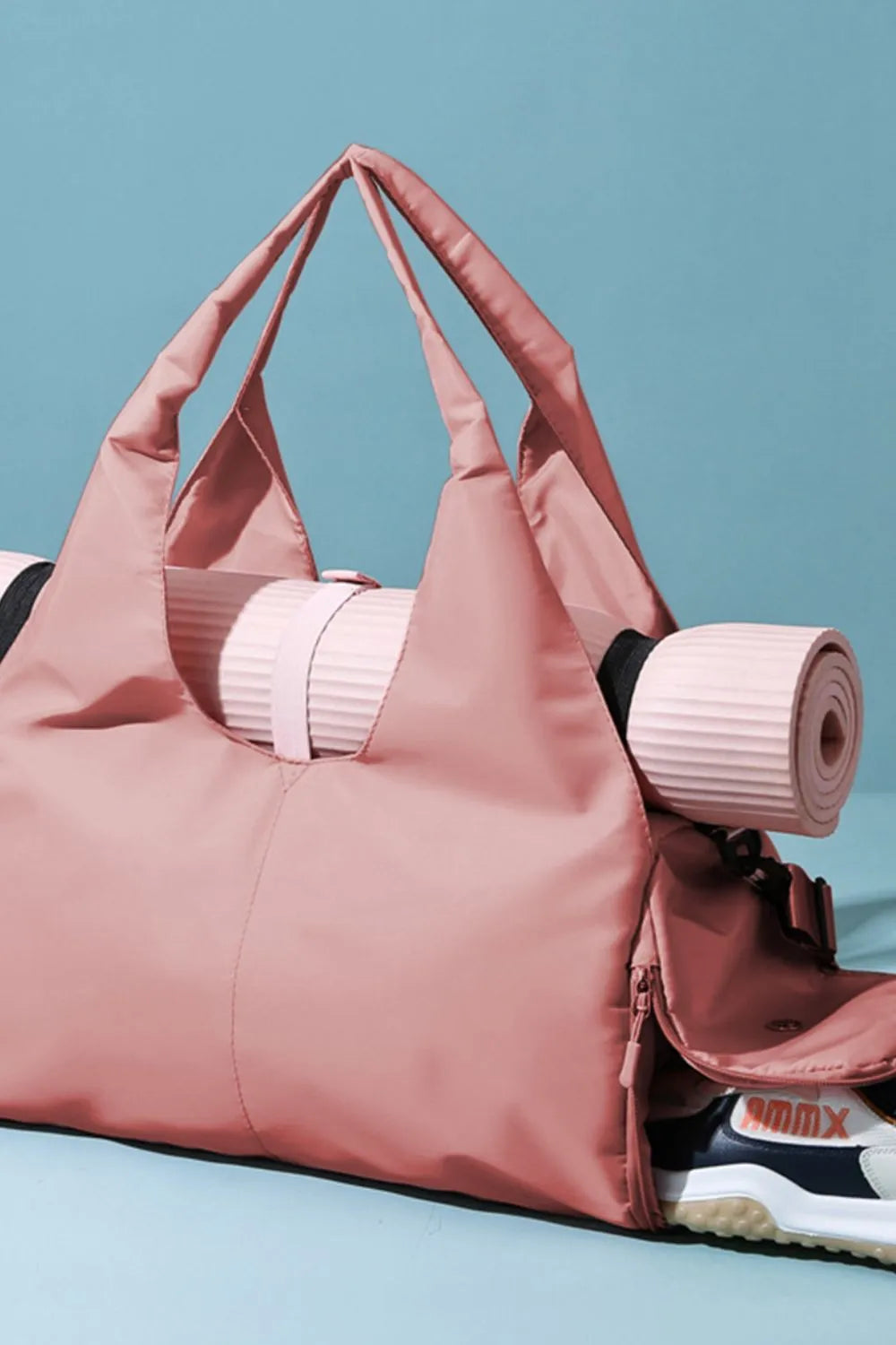Dusty pink waterproof tote bag with side handles and rolled items inside.