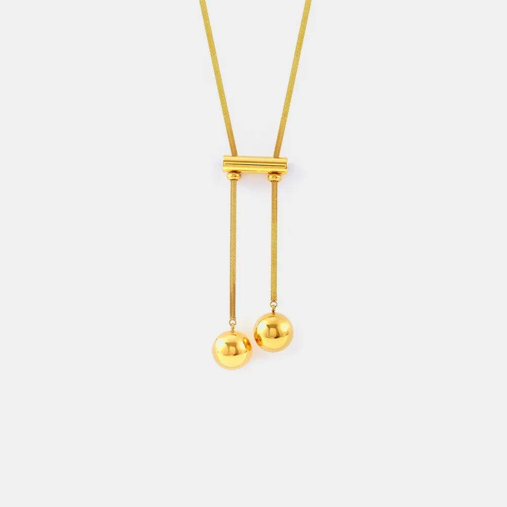 Gold-tone double-strand necklace with bar connector and two round hollow charms