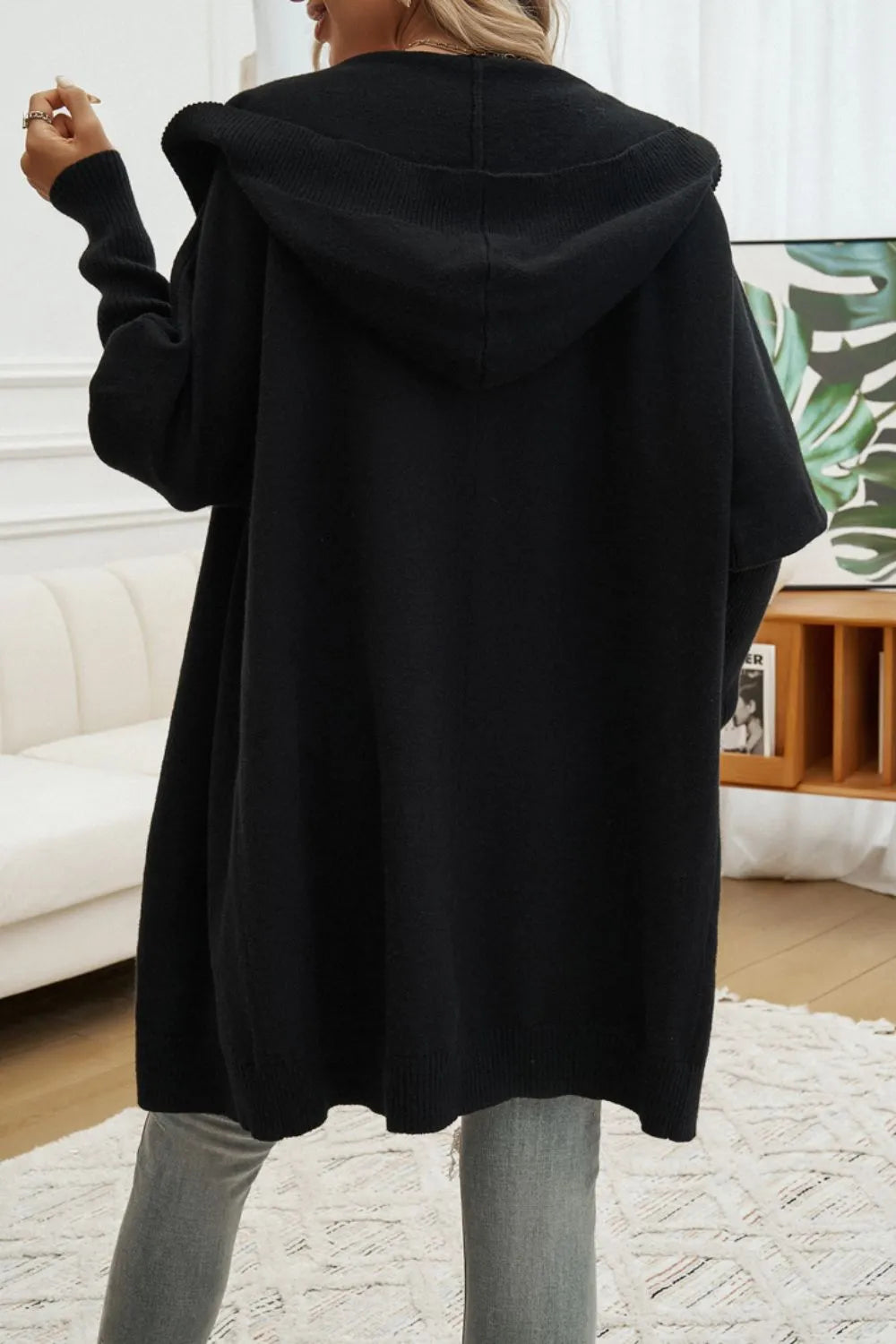 Black hooded cardigan, long sleeves, back view with hood detail.
