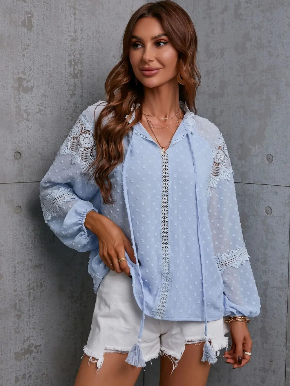 Light blue blouse with tie neck, crochet tassel trim, and long lace sleeves