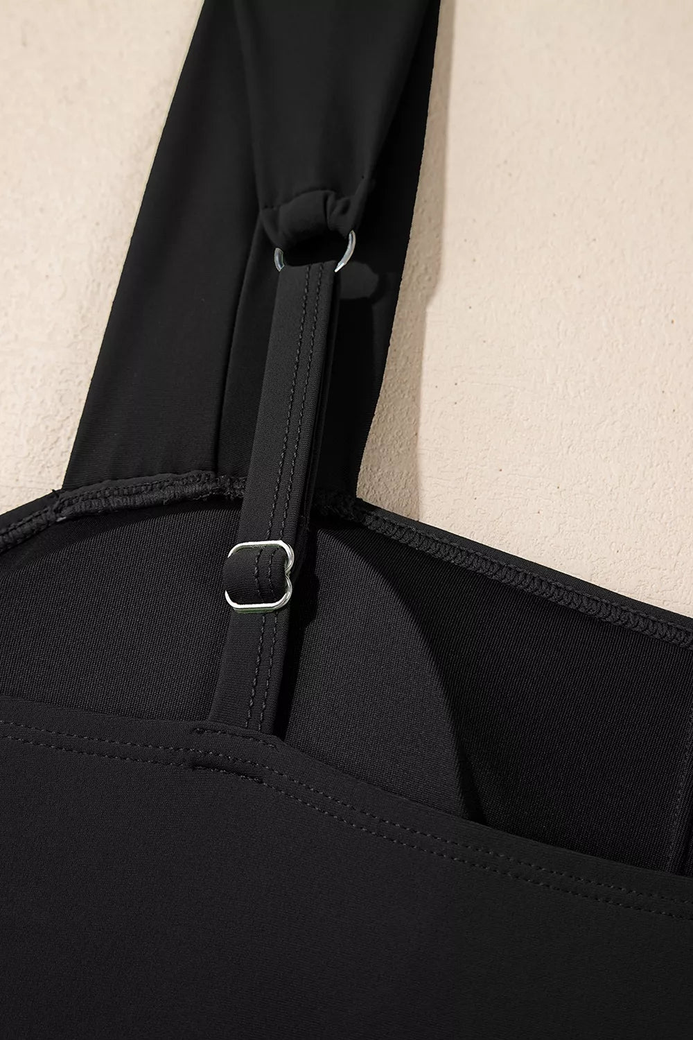 Black swimsuit back strap adjuster with metal rings and stitching