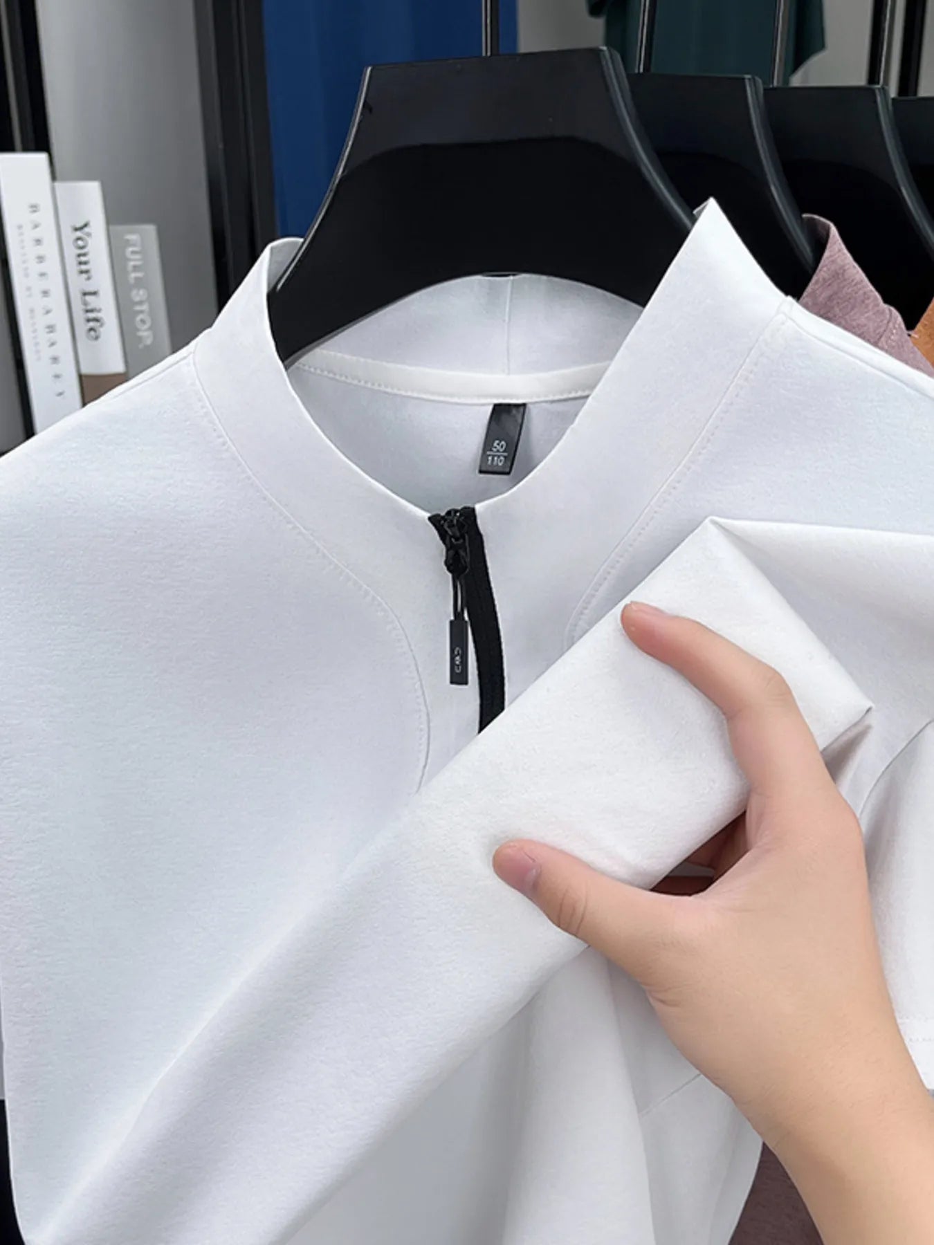 White quarter-zip short-sleeve top close-up of zipper placket and collar