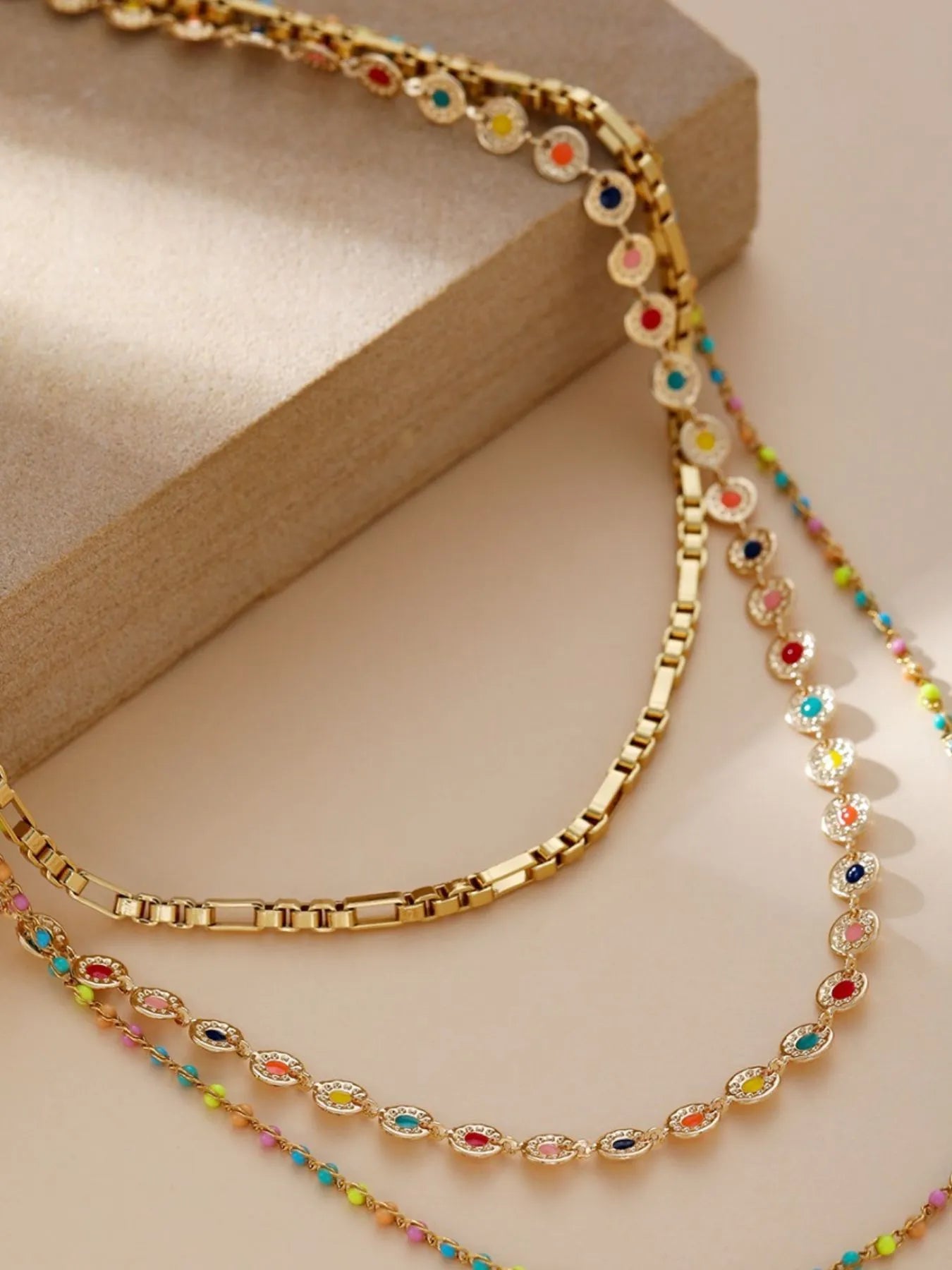 Gold-plated layered resin bead necklace, close view of oval beads and link chain