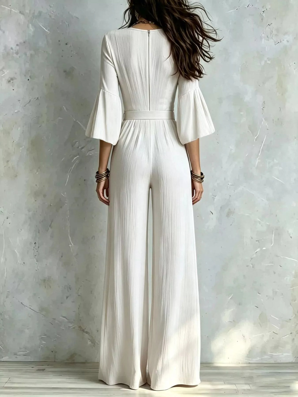 White wide-leg jumpsuit with pleated back waist and flared elbow sleeves