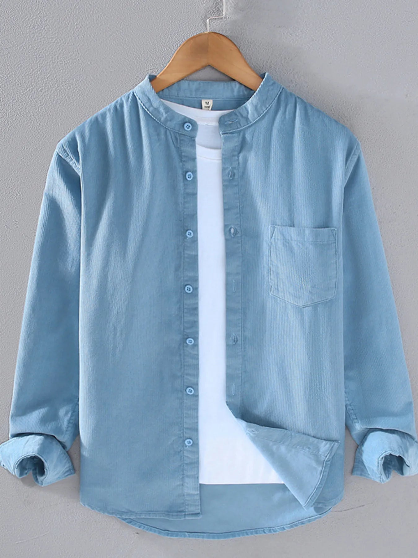 Men's long-sleeve button-up shirt in light blue, with front buttons and chest pocket