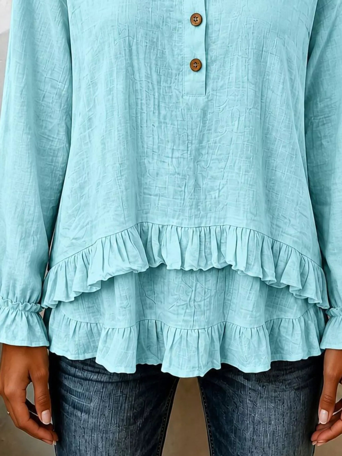 Light blue long-sleeve blouse with tiered ruffle hem and round button front